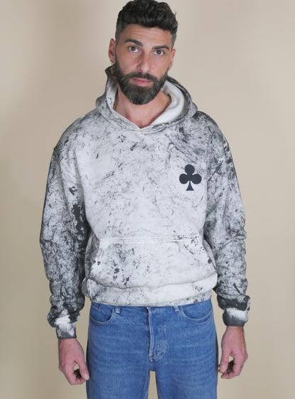 Hoodie à teinture végétale en coton French Terry, effet organique et grand trèfle signature sur la poitrine.